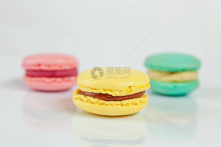 甜杏仁五颜六色的粉红色蓝色黄色马卡龙或马卡龙甜点蛋糕隔离在白色背景上法国甜饼干最小的食品烘焙概图片