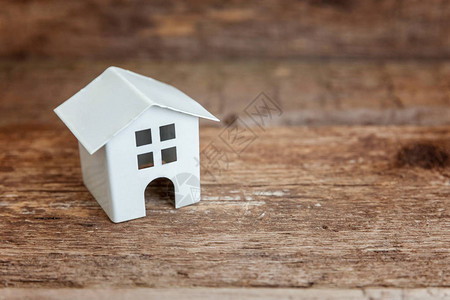 木制背景中的微型白色玩具模型房子图片