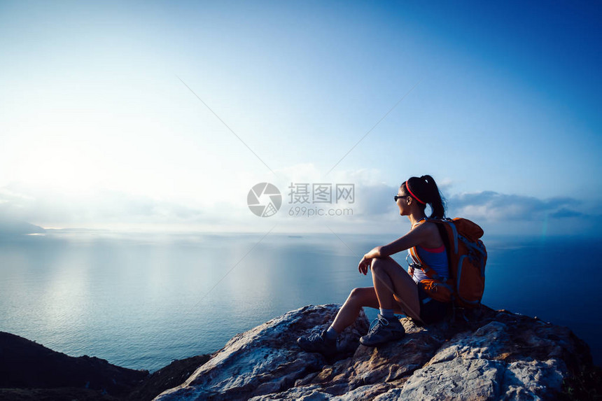 坐在海边山峰的青年女图片