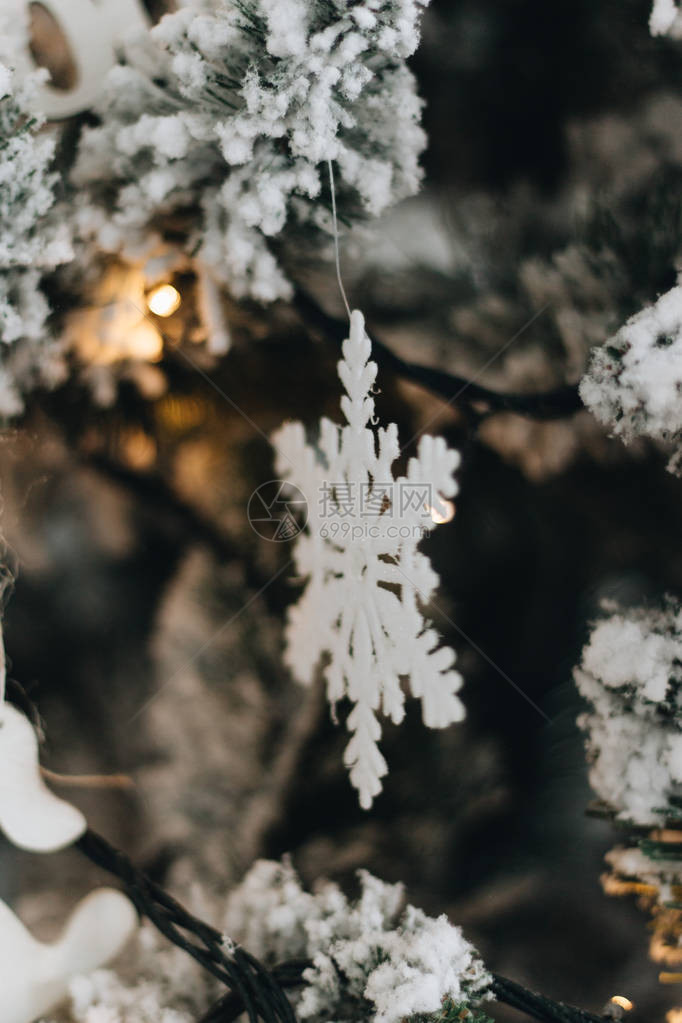 用白雪皑的树枝和雪花木制摆设装饰的圣诞树图片