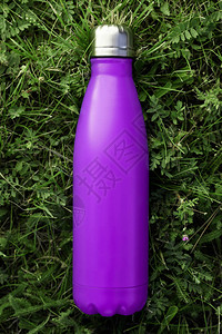 在野外绿草中隔绝的不锈热水瓶紫色边膜颜色无效图片