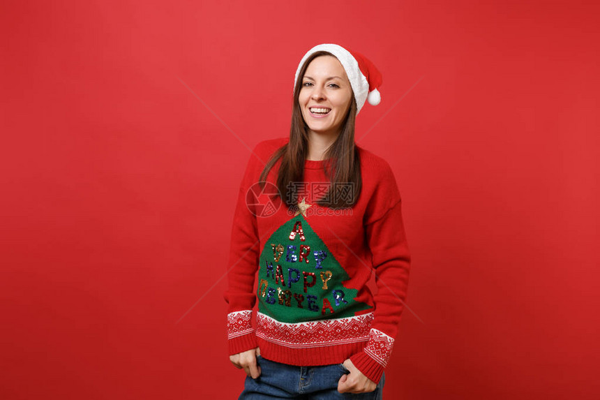 美丽快乐的年轻女孩在针织毛衣圣诞帽子手牵着手在明亮的红色上孤立的口袋里新年快乐2019庆祝节日派对理念图片