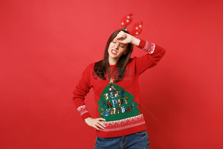 精疲力竭的年轻圣诞老人女孩戴着有趣的装饰鹿角图片