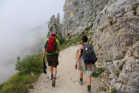 两对徒步旅行者沿着山上陡高清图片