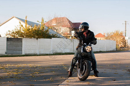 日落时上的人和旧定制咖啡馆赛车摩托车图片