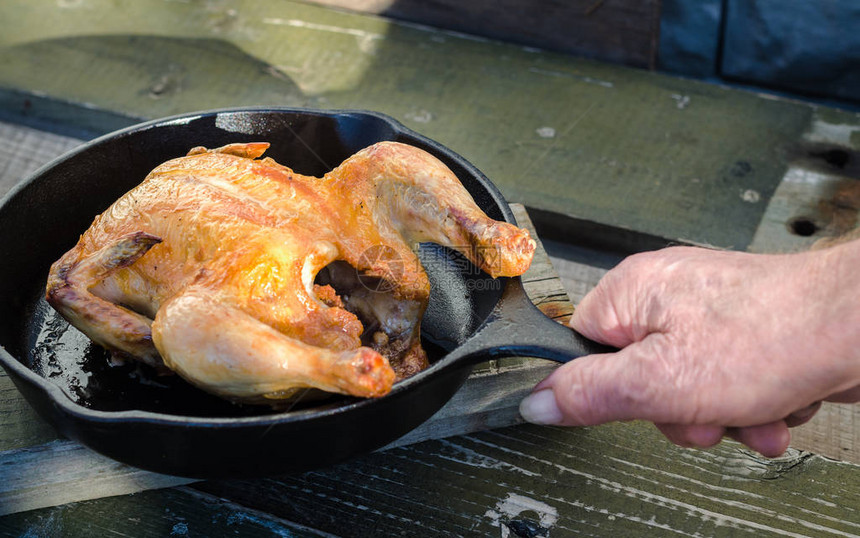 厨师用木制背景的炸鸡餐具把煎锅柄和整只图片