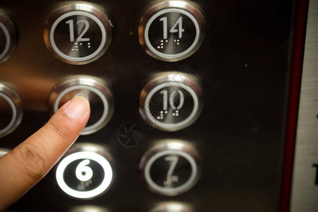 在现代电梯中按下触摸按钮的特写镜头图片