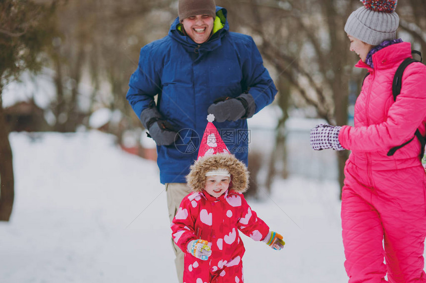 幸福的家庭女人男人和小女孩穿着暖和的衣服跑步图片