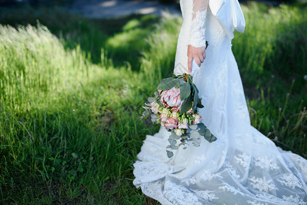 婚礼花束在新娘手中以绿色为背景图片