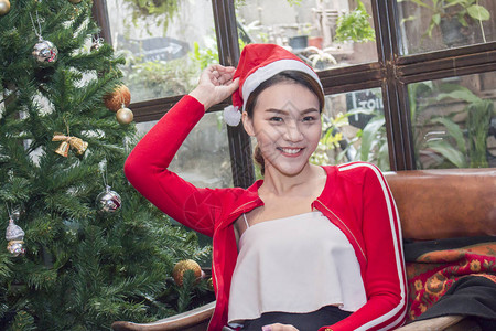 有圣诞树的微笑的亚裔妇女图片