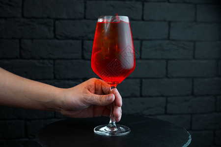 调酒师在优雅的玻璃杯中提供甜美可口的樱桃鸡尾酒图片