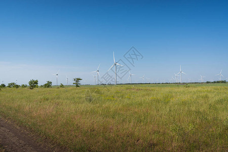 绿地和蓝天空中风力发电机涡轮图片