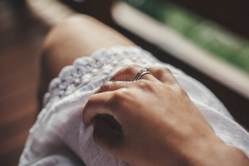 在夏日山的木门廊上女孩穿白色波西米亚裙子时与订婚戒指并肩作战银环带水晶女孩图片