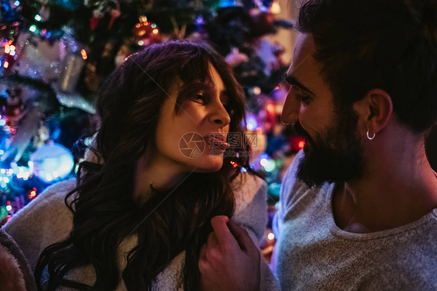 幸福的情侣在圣诞树前玩得开心图片