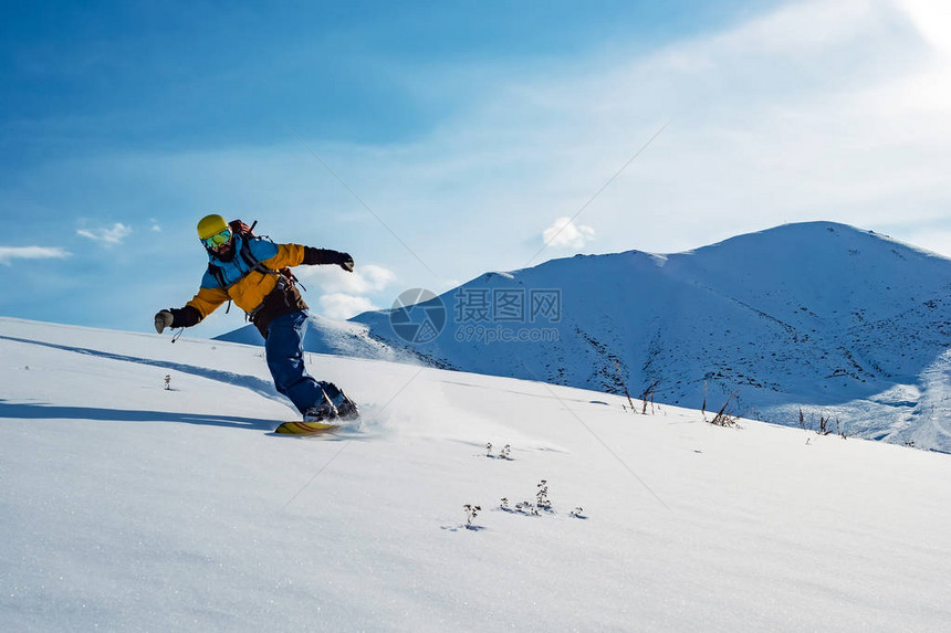 这人骑着雪板在古老的雪地里山上吉尔图片