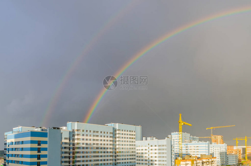 七彩虹在城市高层建筑上空延伸图片