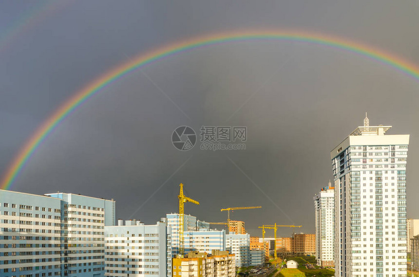 七彩虹在城市高层建筑上空延伸图片