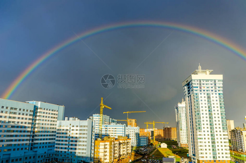 七彩虹在城市高层建筑上空延伸图片