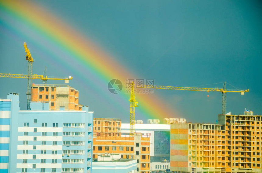 七彩虹在城市高层建筑上空延伸图片
