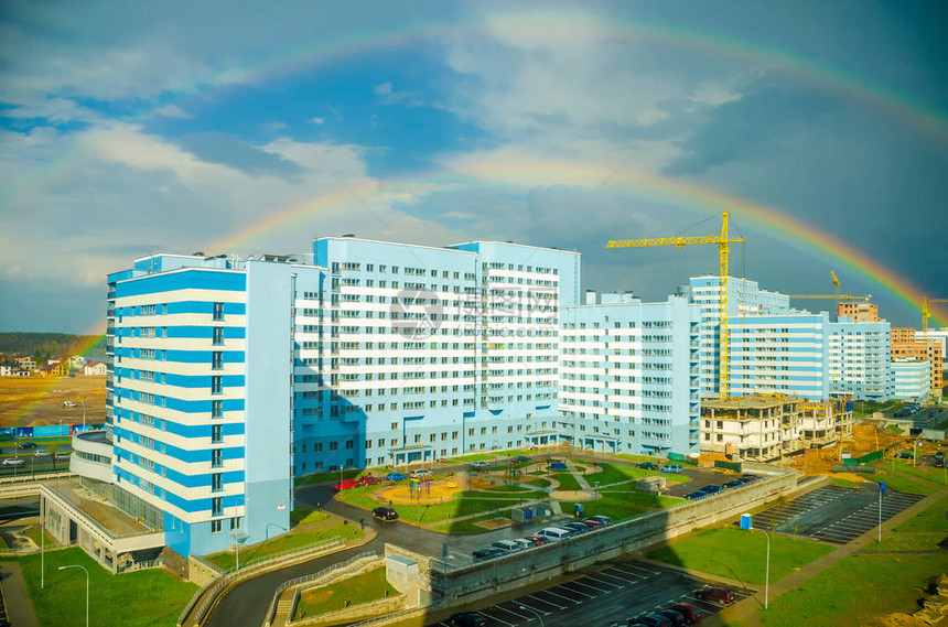 七彩虹在城市高层建筑上空延伸图片