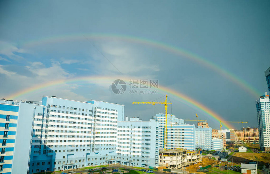 七彩虹在城市高层建筑上空延伸图片