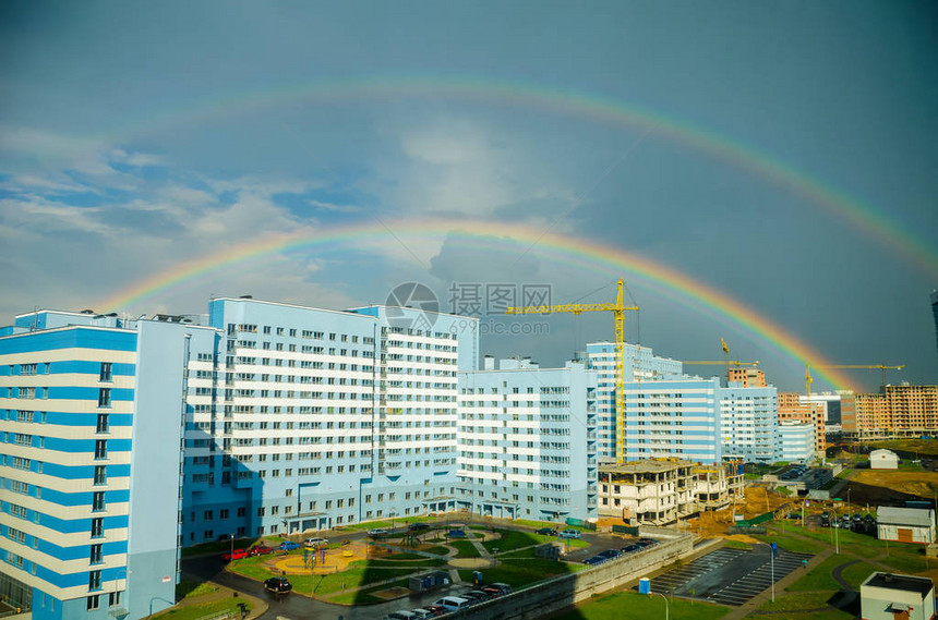 七彩虹在城市高层建筑上空延伸图片