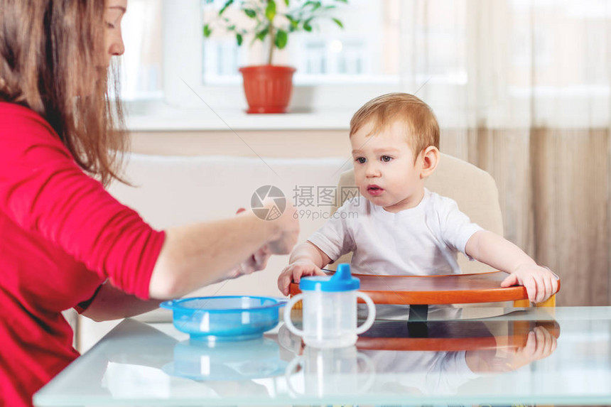 母亲在里用汤匙粥给婴儿喂奶孩子吃健康食物时的情感如果孩子不吃的图片