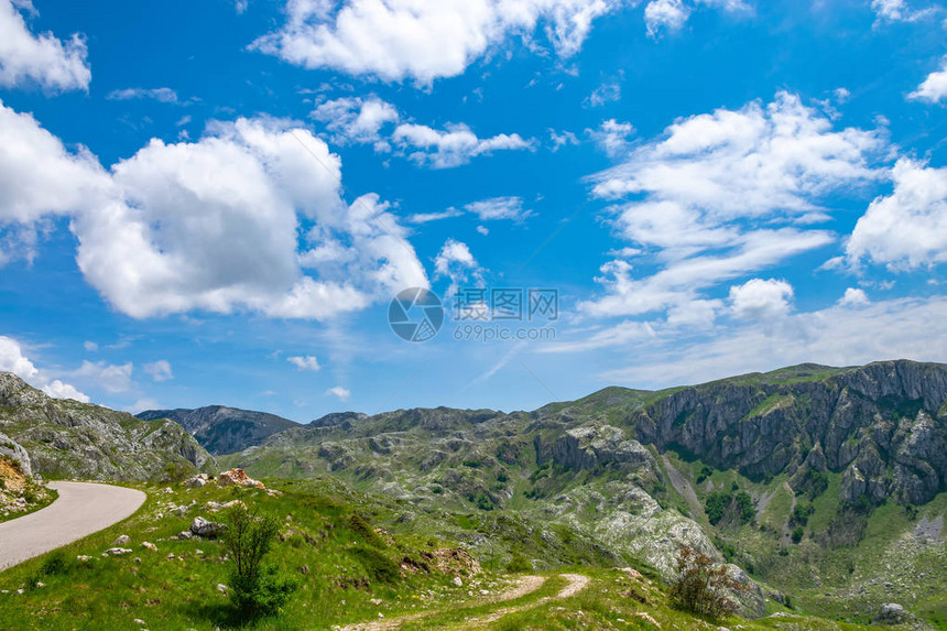 蜿蜒狭窄的道路穿过风景如画的草地和山脉图片