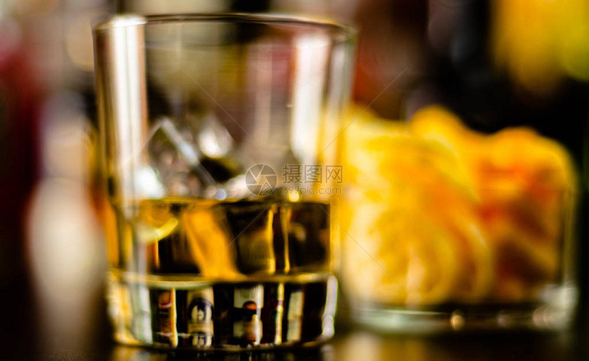 杯威士忌加冰块和咸点心在酒吧背景派图片