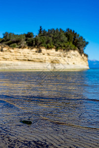 空绿色玻璃瓶扔在科孚海滩上本底沙悬崖被污染的海岸阳光明媚的晴天春图片