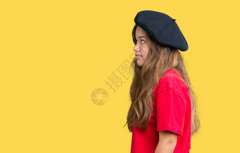 年轻漂亮的黑发时尚女穿着红色T恤和黑色贝雷帽图片