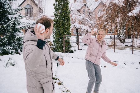 快乐的夫妇在冬天玩雪球图片