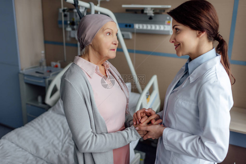带着微笑的女医生与在医院患癌症的手巾上戴头巾的图片