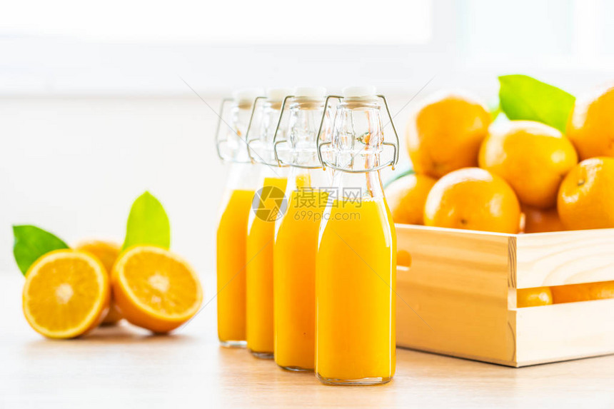 用于在木制桌上用瓶装玻璃杯饮料的新鲜橙子汁图片