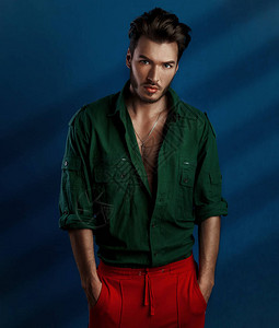 穿着绿衬衫和红裤子的青年男子时装肖像画图片