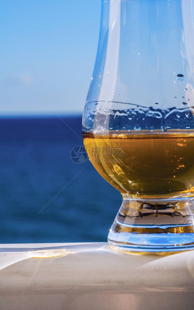 纯麦威士忌在一杯海面上品尝的酒杯中独家和独特的图片
