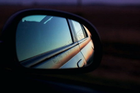 黑暗中日落时的汽车镜子图片