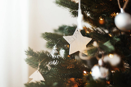 关闭时尚的圣诞树玩具和树枝上的花环灯和圣诞节家图片