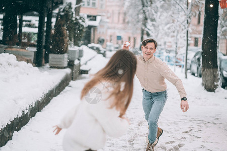 欢乐的年轻夫妇在街上玩雪球图片