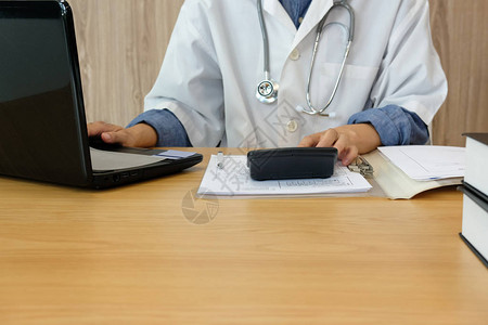 医生用听诊器计算医疗费用成本和收入从业者在诊所医图片