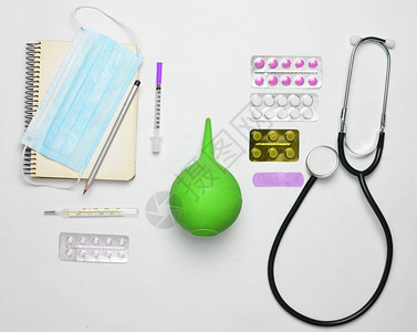 白色背景上的医疗设备听诊器平板电脑温度计笔记本注射器灌肠剂医学概念图片