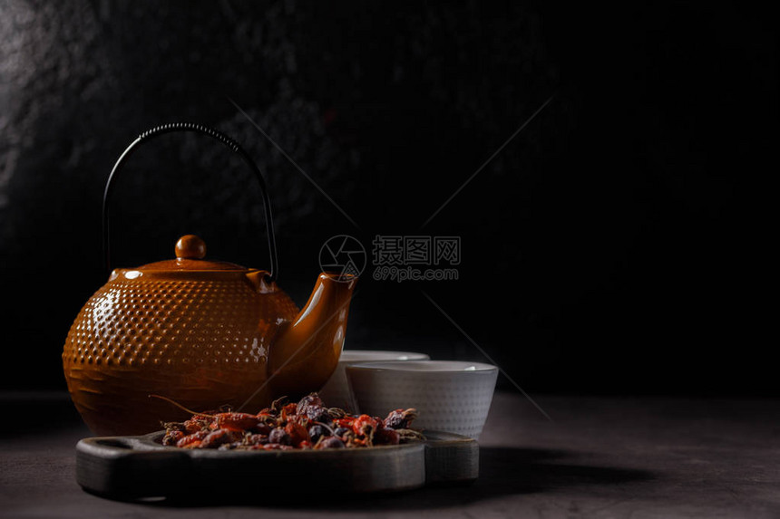 茶仪式泡茶过程茶壶和杯子新鲜的维他命饮料来自玫瑰花暗淡的心图片
