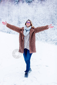 在雪林中穿大衣的漂亮女孩情人节圣图片