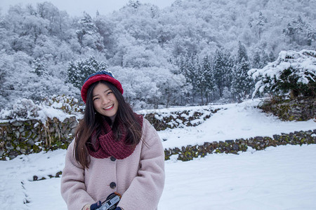 亚洲快乐女孩在冬季白川果村下雪时微笑脸图片