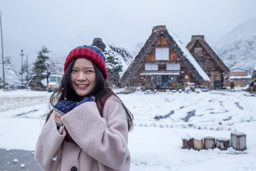 亚洲快乐女孩在冬季白川果村下雪时微笑脸图片