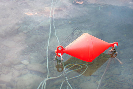 红色锚浮标位于清澈的海水上图片