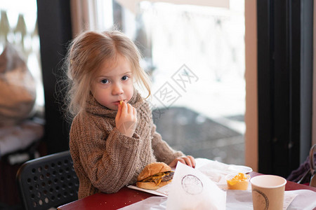 小女孩在咖啡馆吃汉堡图片