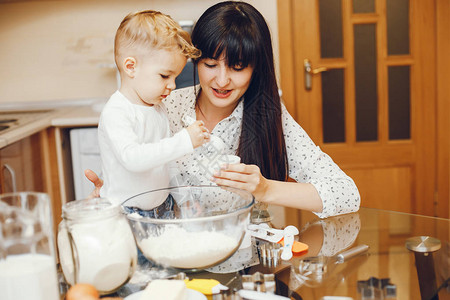 一个身着白衬衫的年轻母亲正在厨房做饭图片