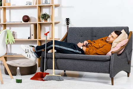 英俊的男人睡在现代客厅的沙发上图片