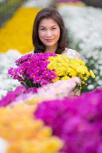 美丽的亚洲女人手捧黄花图片